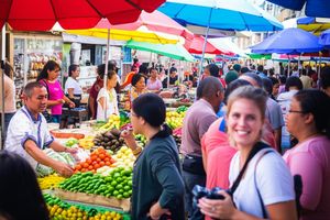 Bustling local market scene with diverse people interacting and trading, showcasing authentic community life.