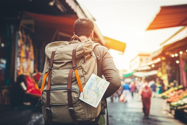 Traveler with heavy backpack in a bustling Marrakech souk, looking overwhelmed by over-planning.
